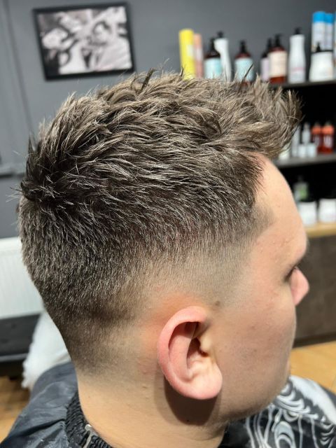 Męska fryzura Textured Crop z cieniowaniem Mid Fade na bokach.