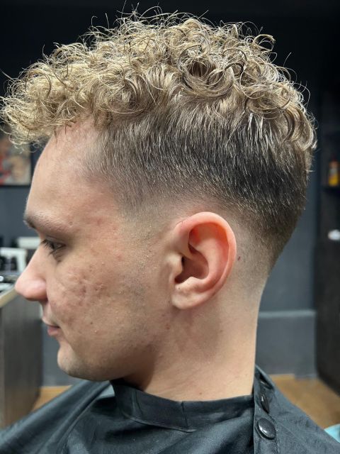 Męska fryzura z naturalnymi lokami na górze i precyzyjnym cieniowaniem typu Low Fade na bokach - Barber Jawor